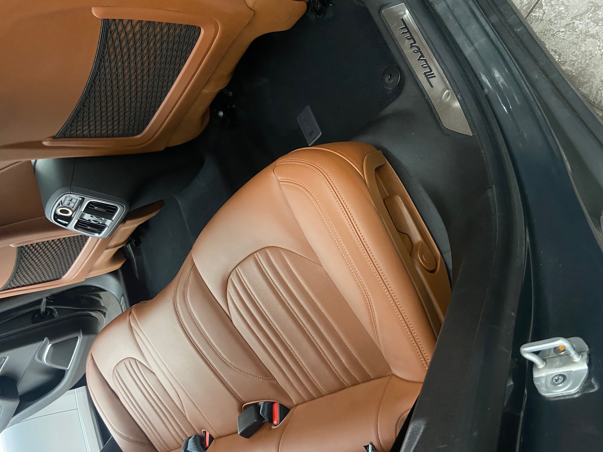 Detailed Maserati rear passenger area with tan leather seats